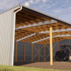 A large open-sided farm shed with wooden supports and a tractor parked inside.