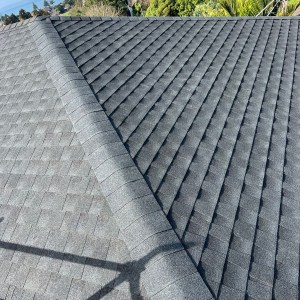 A grey asphalt shingle roof with a clear view of the ridge