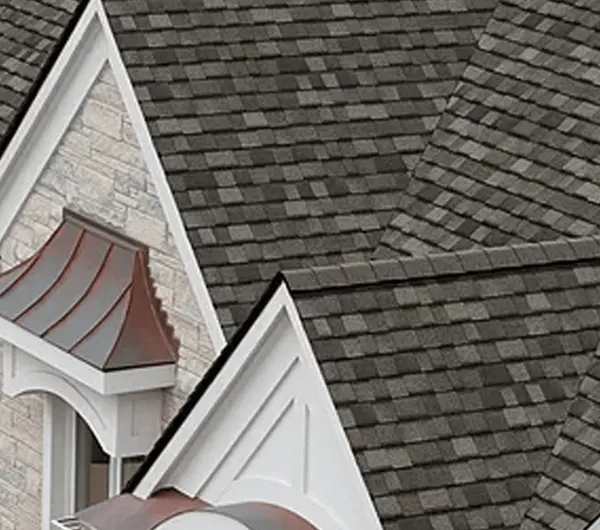 Elegant architectural roof with dark gray shingles and detailed dormer designs.