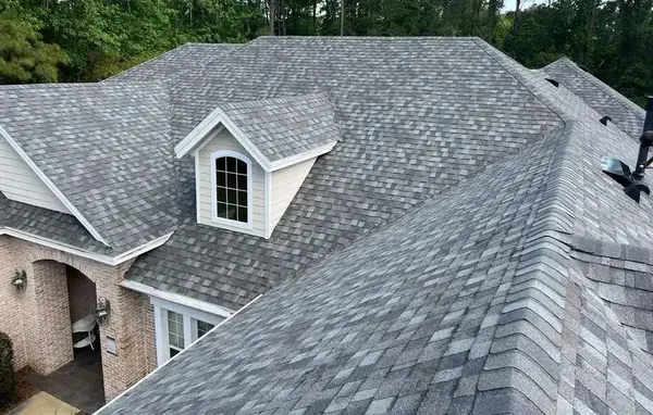 Close-up view of a house with a newly installed gray shingle roof.